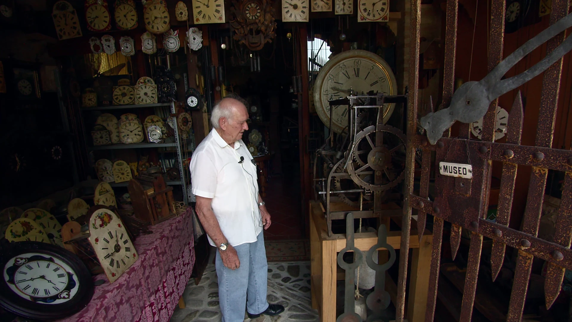 Giuliano Ansaloni osserva un grande meccanismo tra gli orologi della sua collezione