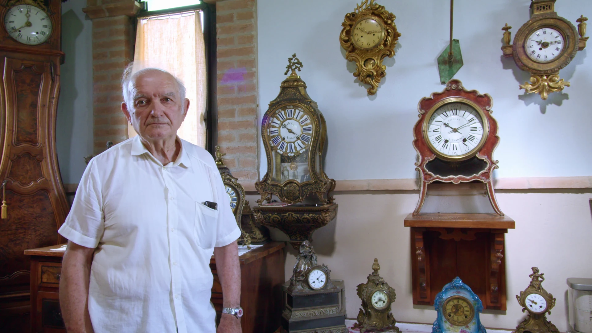 Giuliano Ansaloni nella sua casa museo, circondato da orologi